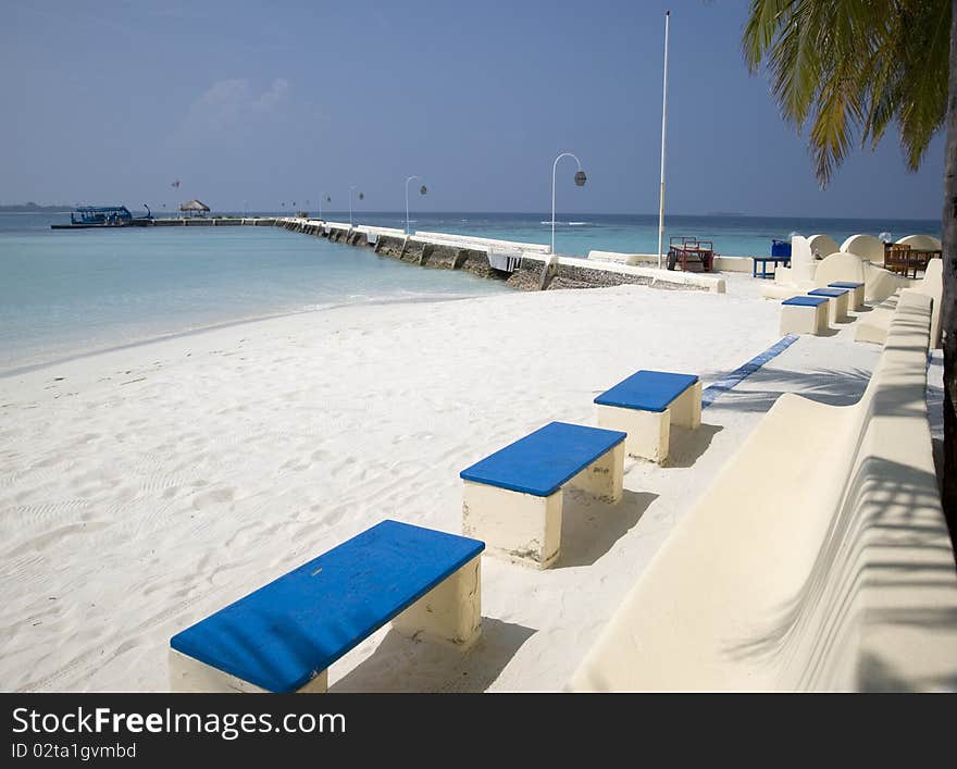 Maldives. A view with ocean, coast and a raw of benches. Maldives. A view with ocean, coast and a raw of benches