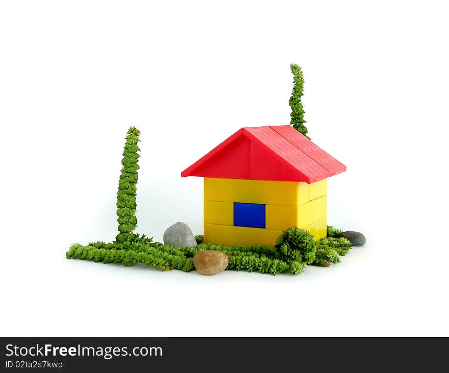 The yellow house with a red roof on a green grass. The yellow house with a red roof on a green grass