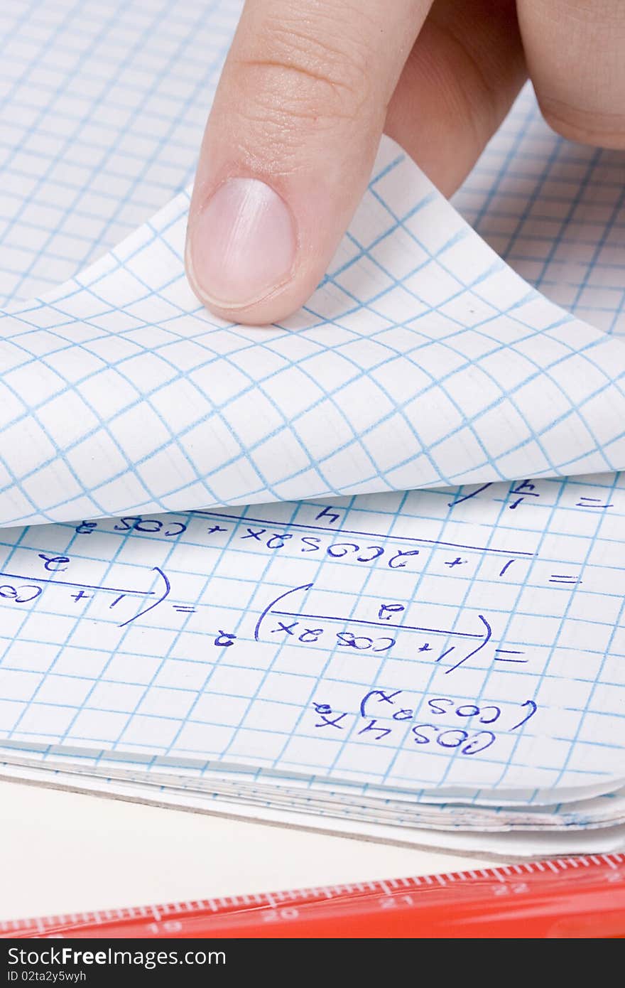 Student folding a page in a math notebook.