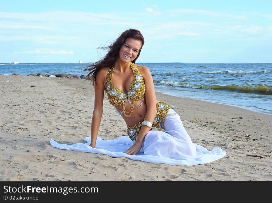 Beautiful sitting woman in white exotic dress