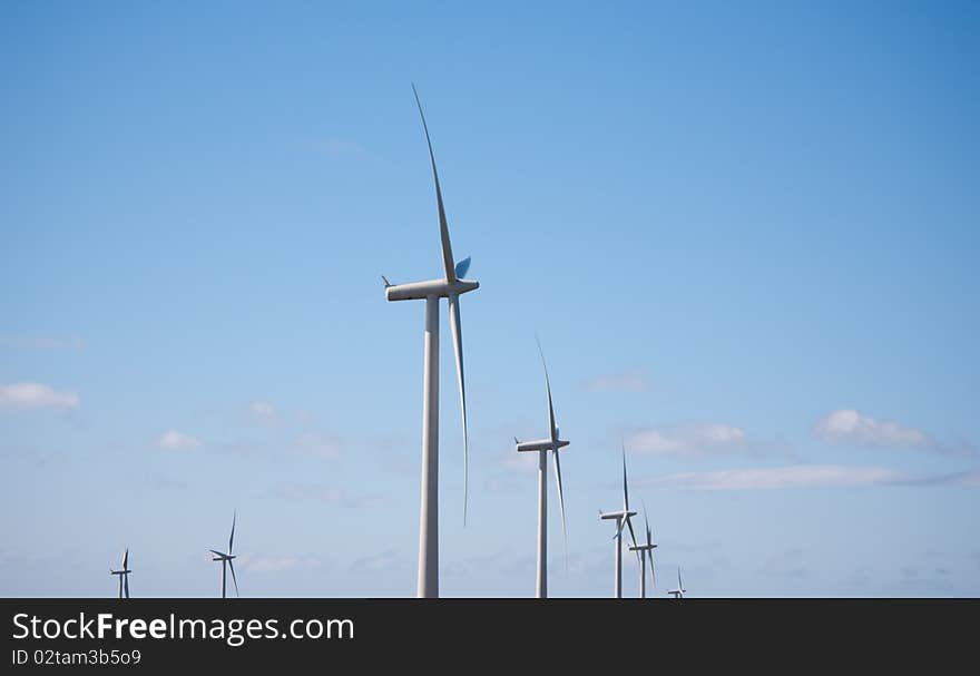 Line of wind turbines and blue sky