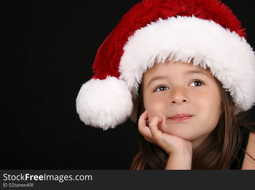 Cute little brunette girl wearing a christmas hat. Cute little brunette girl wearing a christmas hat