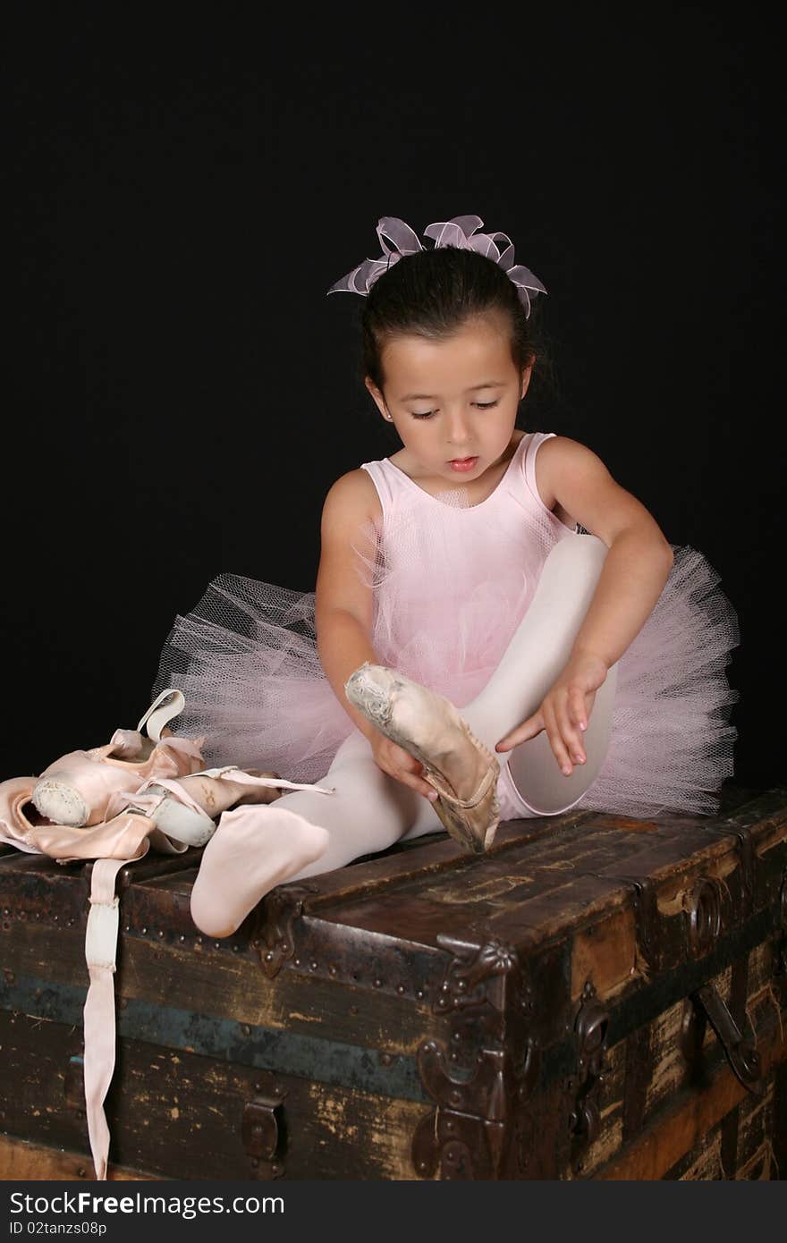 Cute little brunette girl trying on ballet pointe shoes. Cute little brunette girl trying on ballet pointe shoes