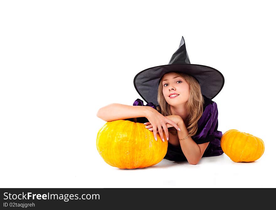 Pretty young blond woman dressed as a fairy with pumpkins