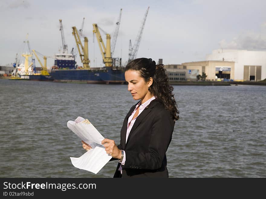 Young businesswoman watching at a map in port of Rotterdam. Young businesswoman watching at a map in port of Rotterdam