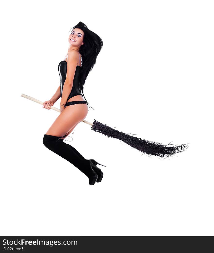 Pretty young brunette witch flying on a broom. Pretty young brunette witch flying on a broom