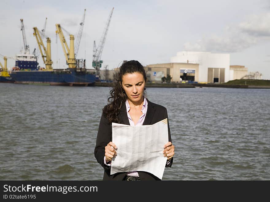 Young businesswoman watching at a map in port of Rotterdam. Young businesswoman watching at a map in port of Rotterdam