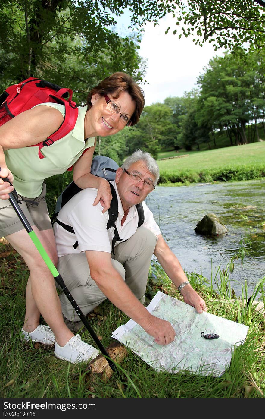 Senior couple looking at map and compas on hiking day