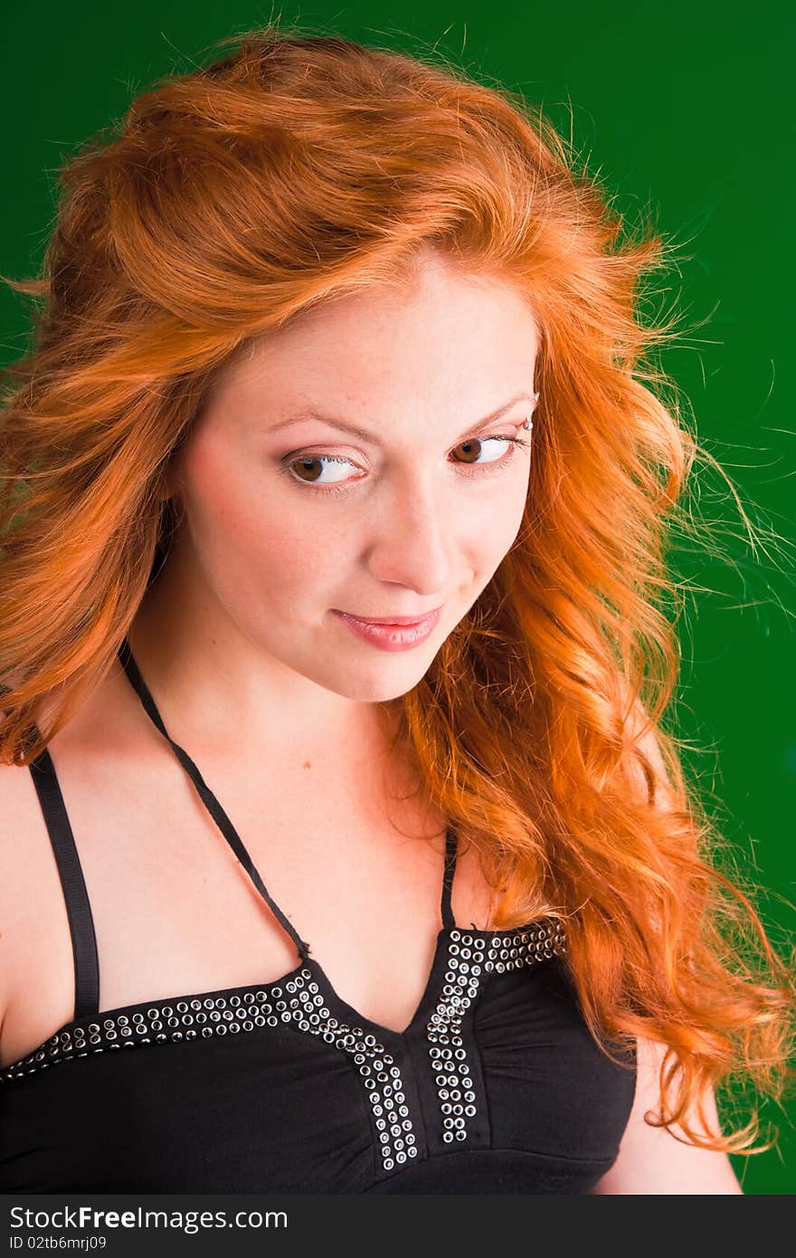 Beautiful red-haired woman with a worried look in black sarafan on a green background. Beautiful red-haired woman with a worried look in black sarafan on a green background