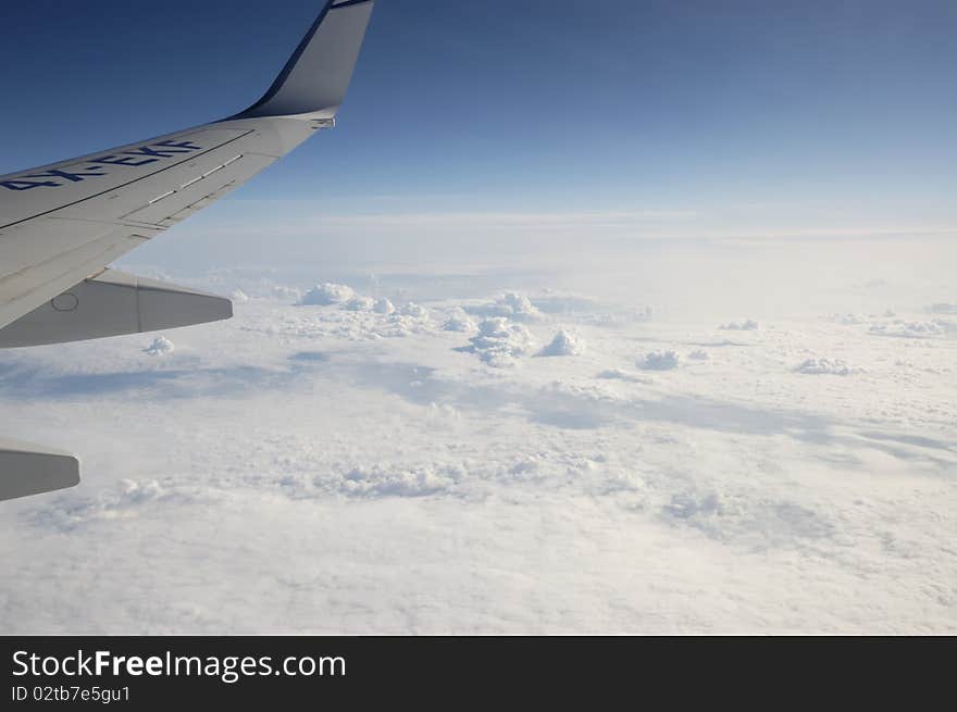 View of jet plane wing with cloud patterns above North Atlantic. View of jet plane wing with cloud patterns above North Atlantic.