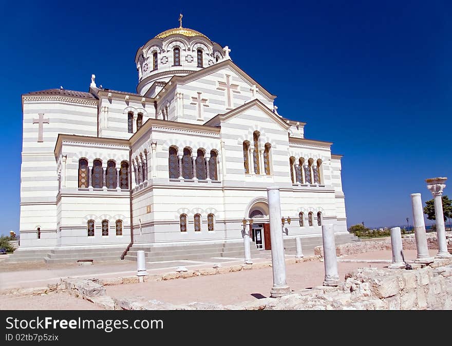 Ancient ruins against orthodox church