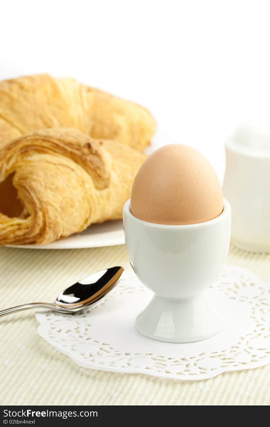 Breakfast table with egg and croissants