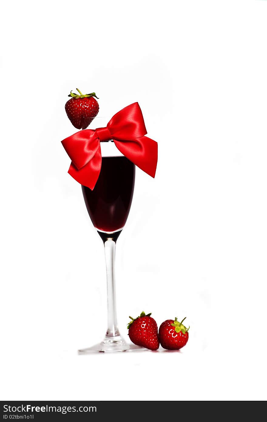 Strawberry and red bow as decoration on the glass of alcohol. Strawberry and red bow as decoration on the glass of alcohol