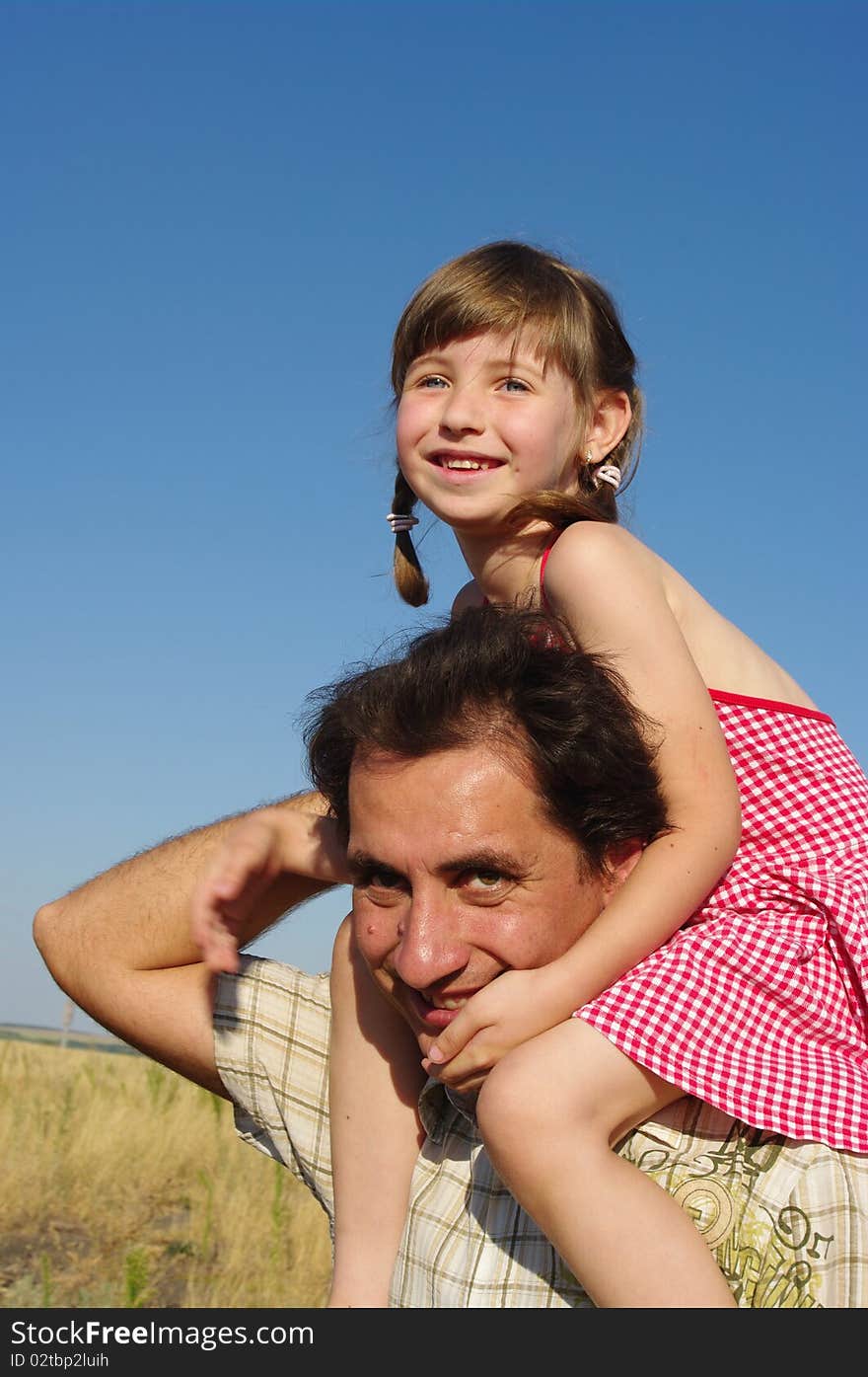 The girl sits on shoulders at the father. The girl sits on shoulders at the father