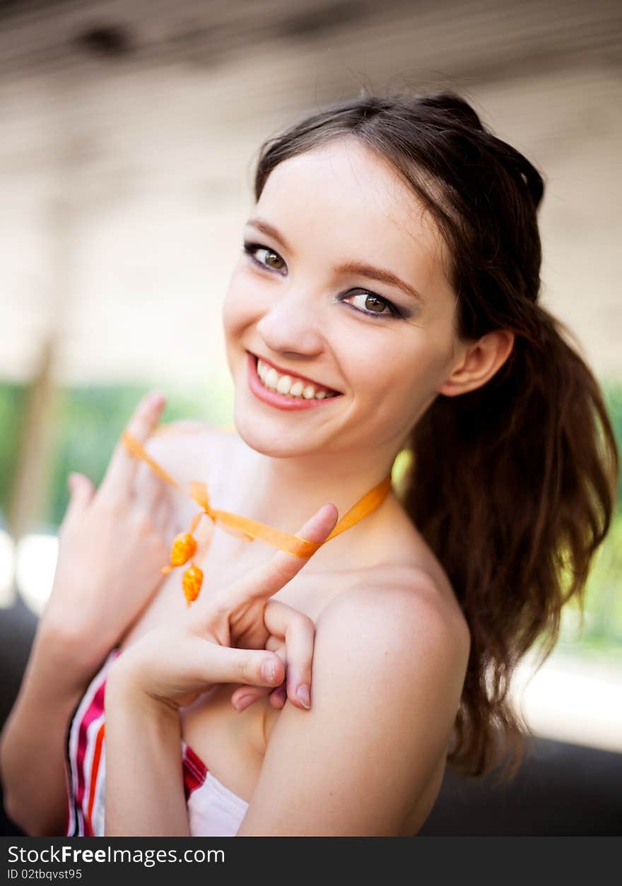 Portrait of a happy young laughing girl wearing a necklace