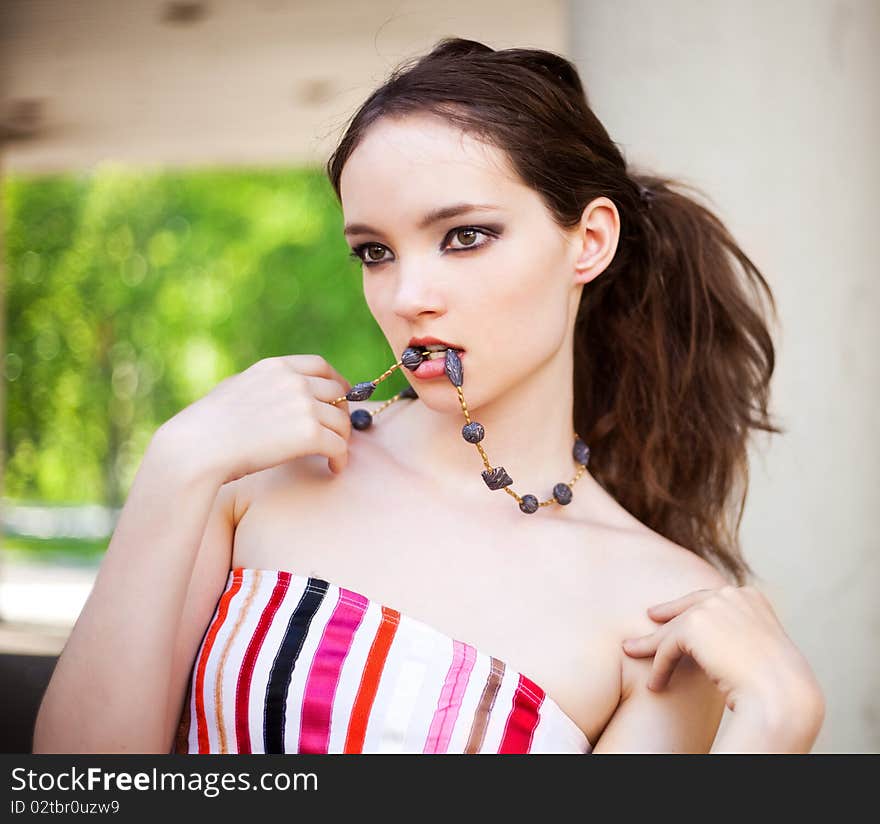 Portrait of a beautiful young brunette model wearing beads