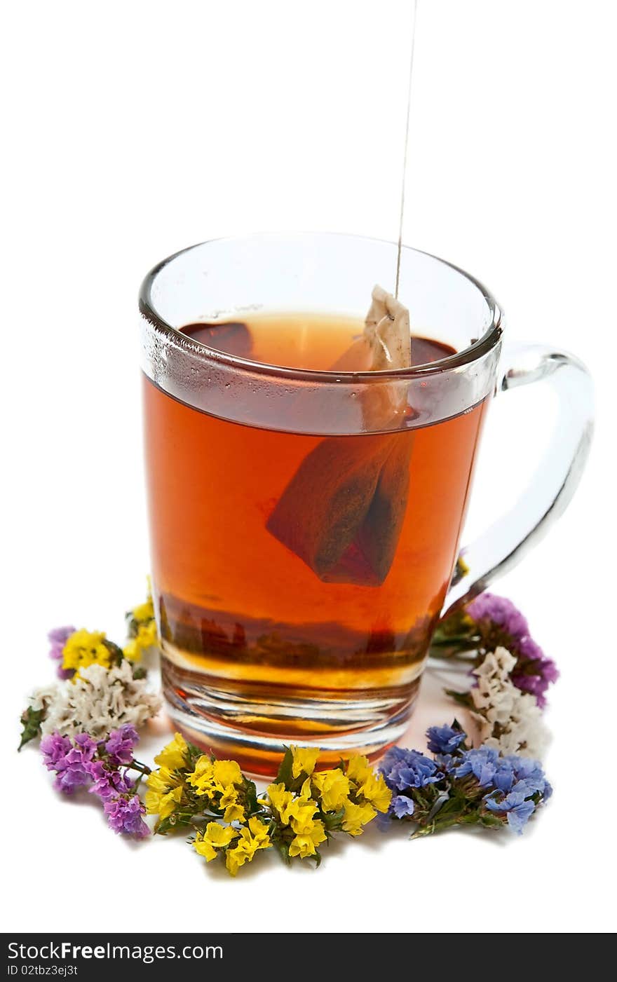 Hot tea in glass cup with flowers. Isolated on white background. Hot tea in glass cup with flowers. Isolated on white background