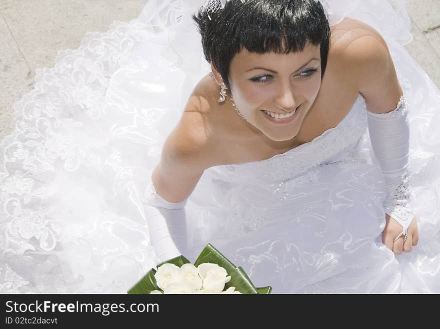 Beautiful and happy bride with a bouquet outdoors. Beautiful and happy bride with a bouquet outdoors.