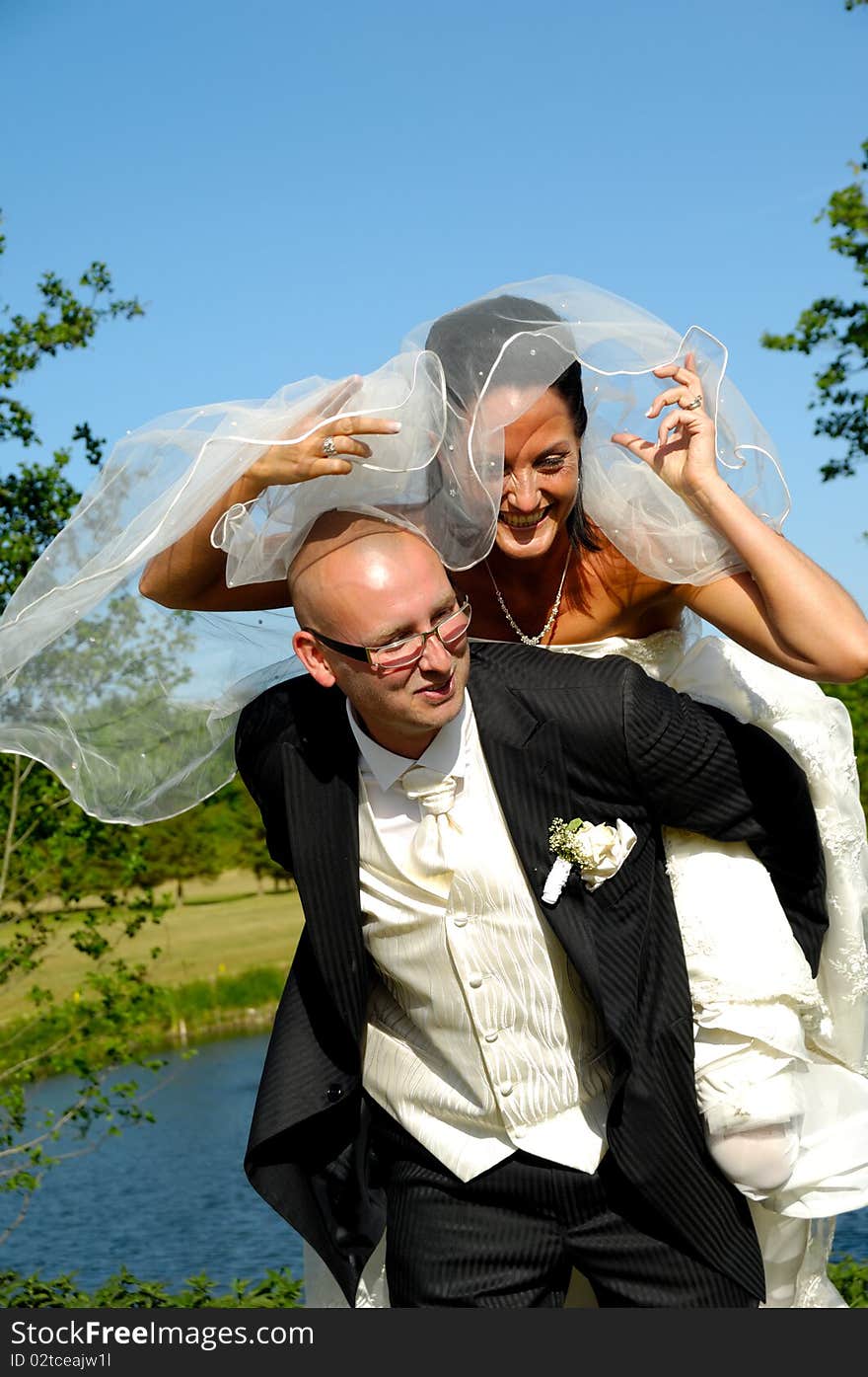 Groom is lifting his bride up in a park. Groom is lifting his bride up in a park.