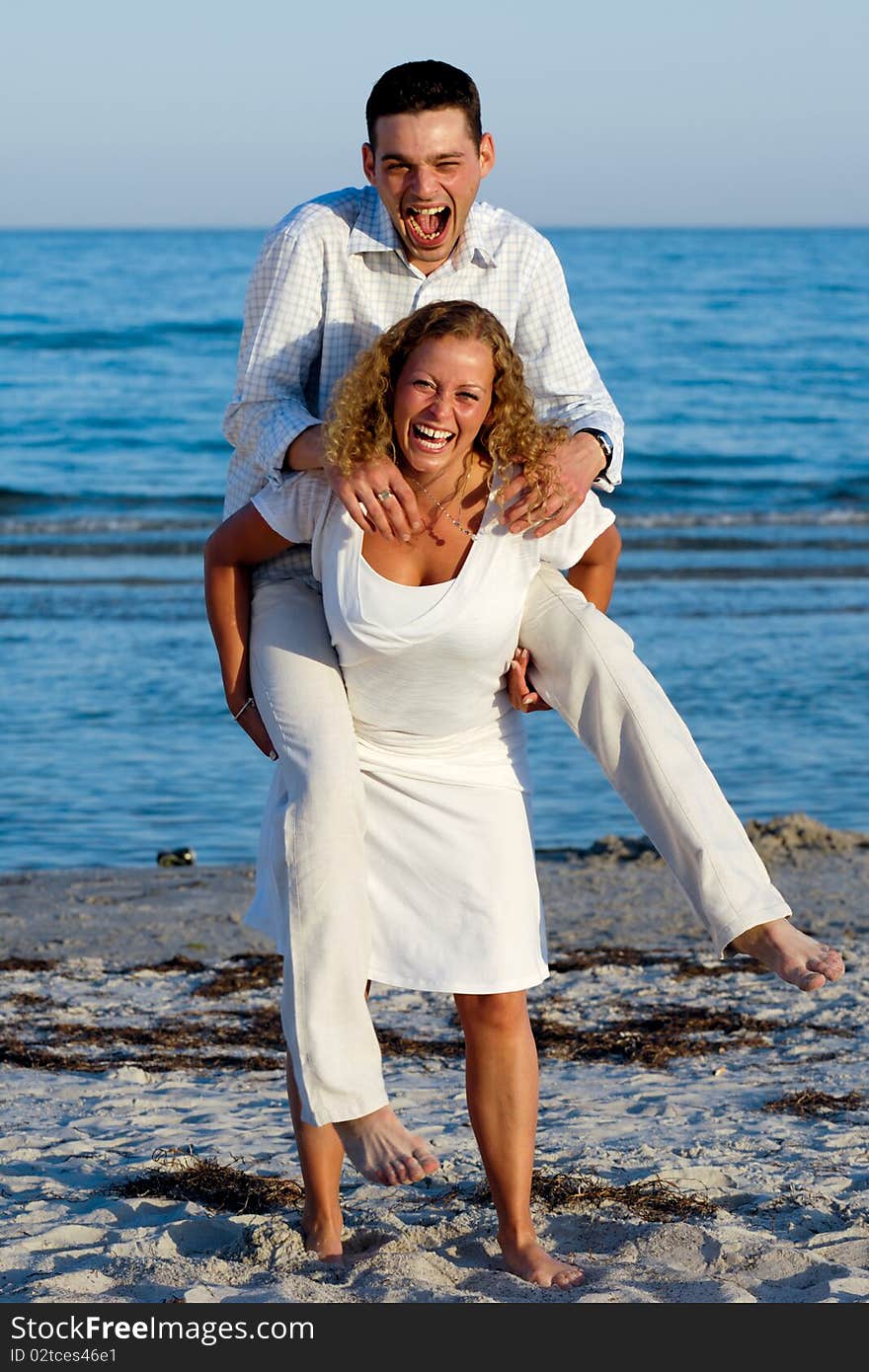 A happy woman and man having fun on beach.