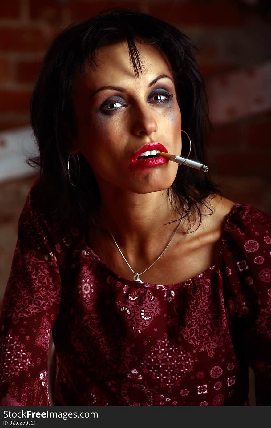 Closeup portrait of a woman with flowing make-up and cigarette