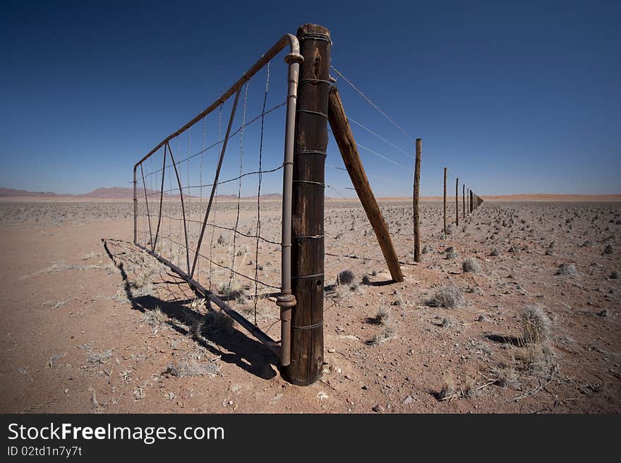 Gate somewhere in Namibia with fence disappearing in the distance. Gate somewhere in Namibia with fence disappearing in the distance.