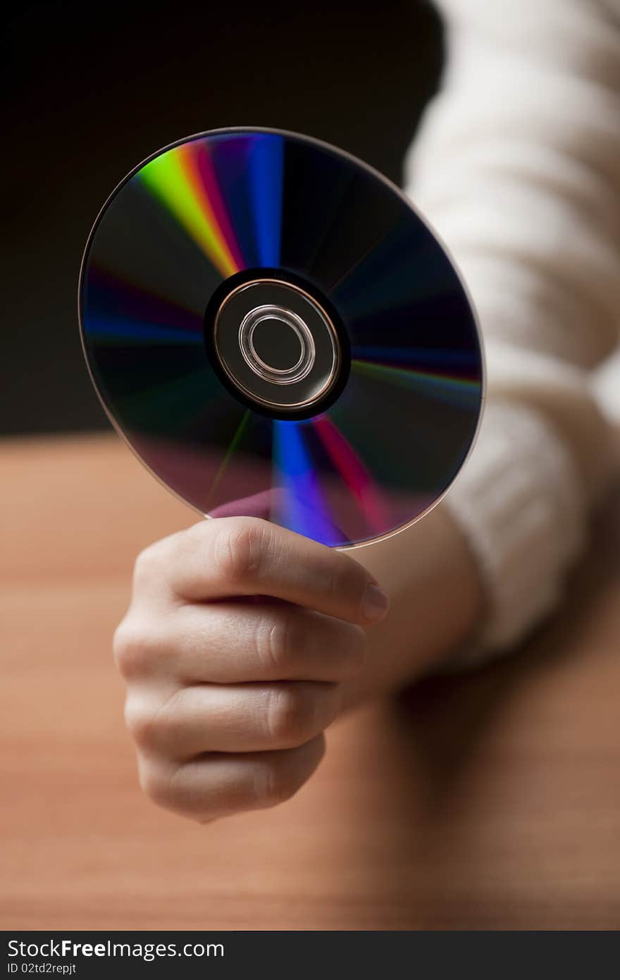 Female hand holding CD, in the office