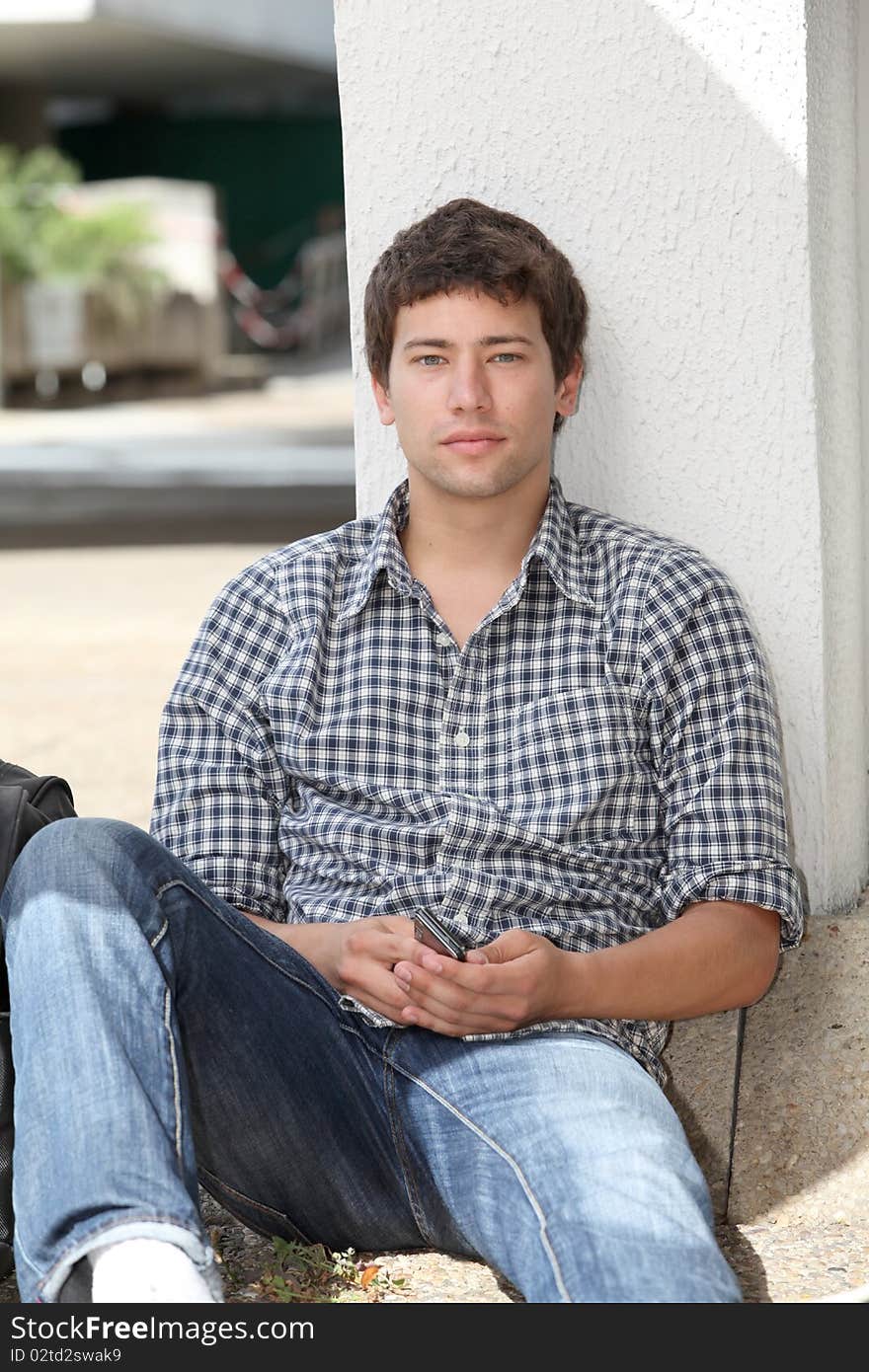 Student sitting against wall