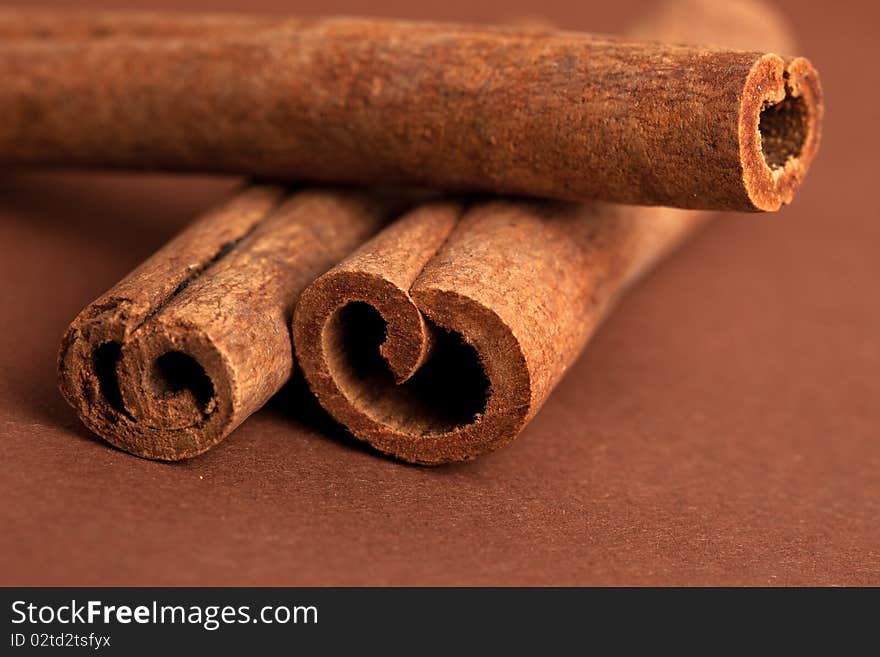 Cinnamon sticks on brown background