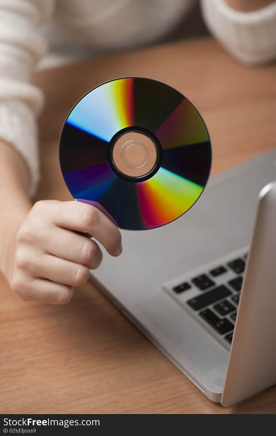 Female hand holding CD, in a office