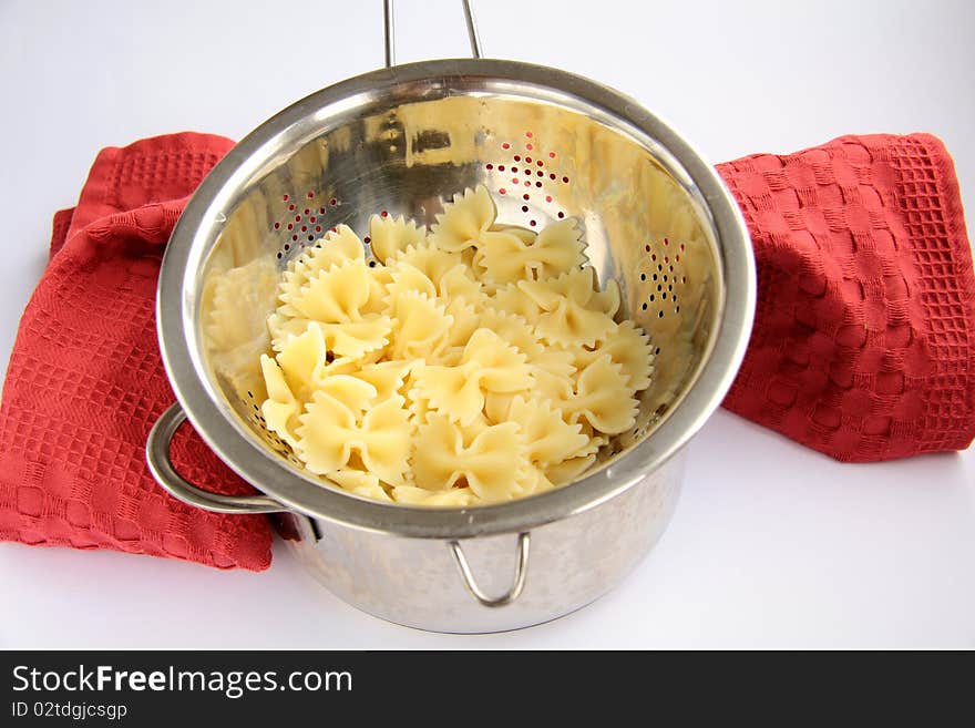 Pasta in a saucepan with a napkin on a white background