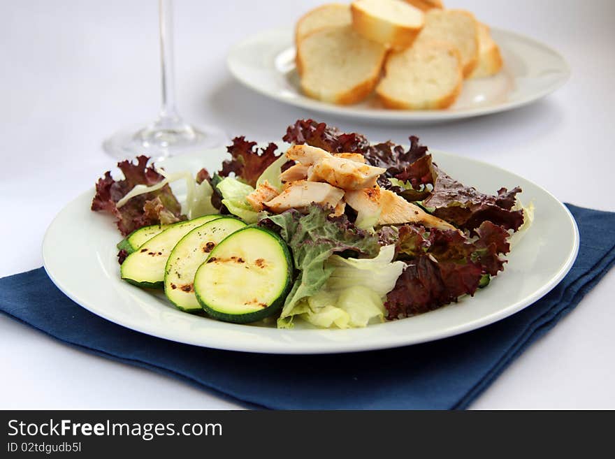 Salad with vegetables and chicken on a white plate