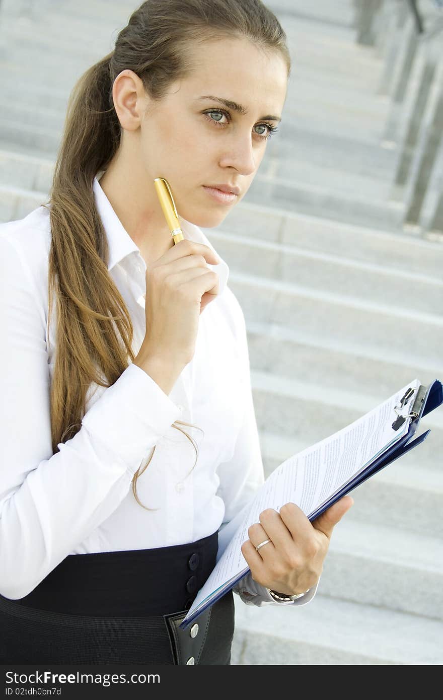 Young Businesswoman lost in thought over the signing of the document. Analyzes. Young Businesswoman lost in thought over the signing of the document. Analyzes