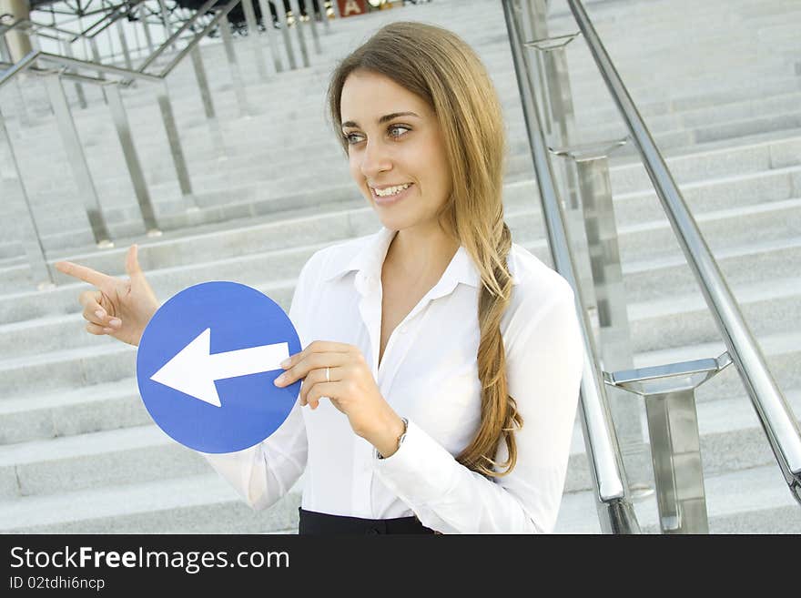 Close-up of a young woman gesturing. In the hands of a traffic sign