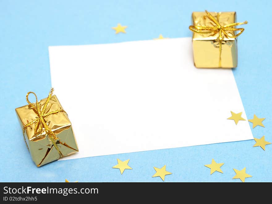 A blank Christmas note with two decorative gifts.