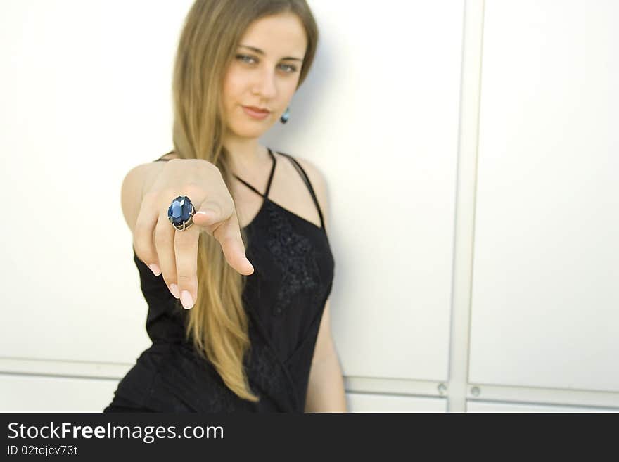 Beautiful girl pointed a finger in the frame. On his finger ring with a large blue gemstone. Beautiful girl pointed a finger in the frame. On his finger ring with a large blue gemstone