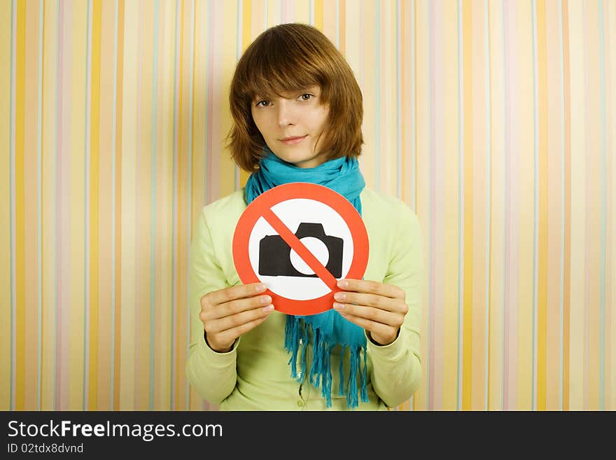 Young girl holding a sign which depicts a sign To photograph is prohibited. Young girl holding a sign which depicts a sign To photograph is prohibited