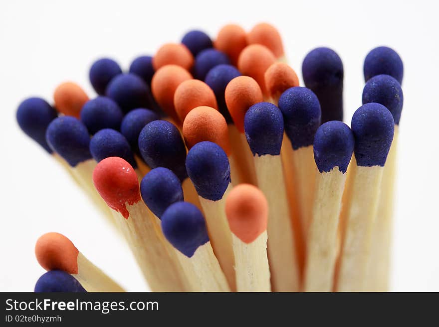 Blue and orange colored matchsticks on white background