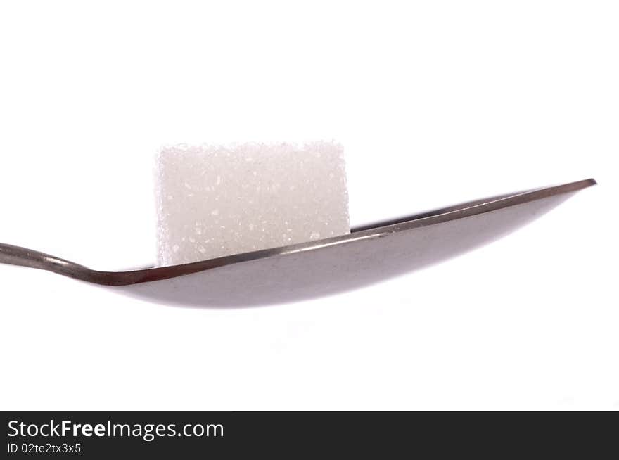 White sugar cube on tea spoon