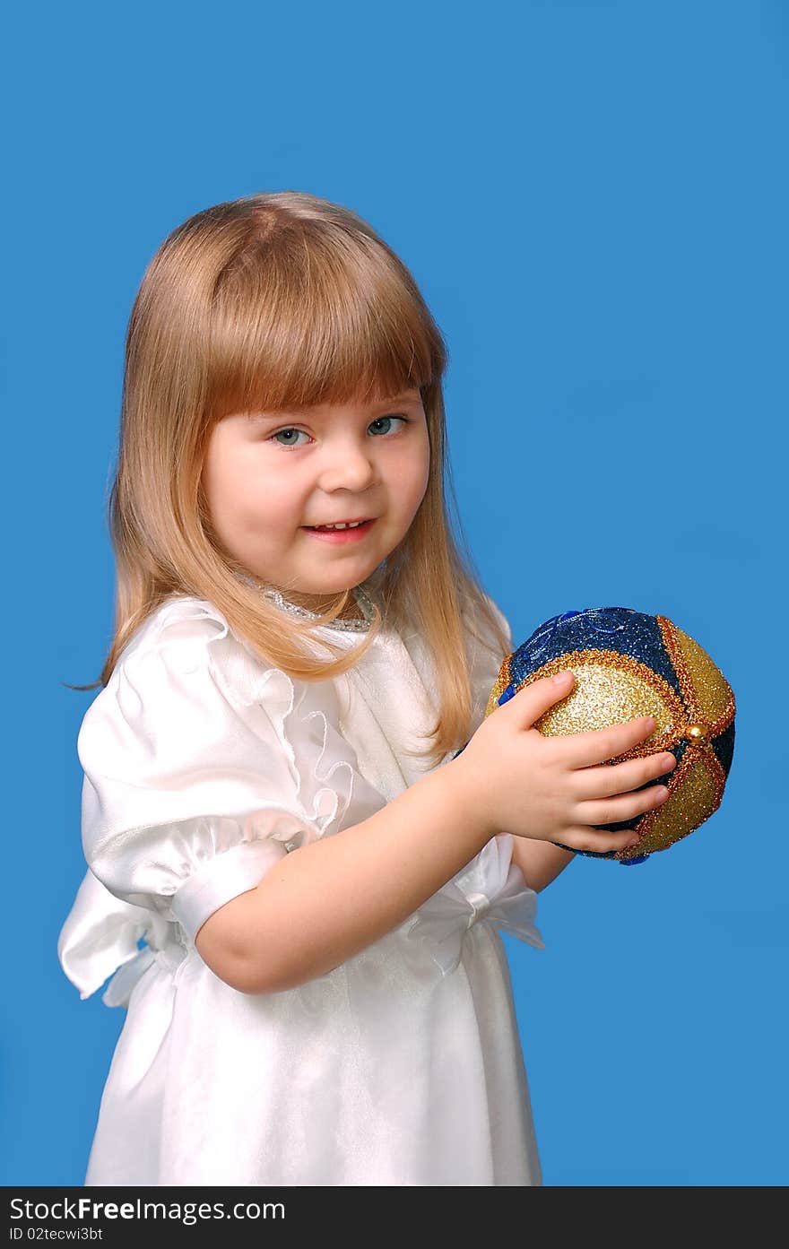 Girl in a white dress holds a New Year s toy