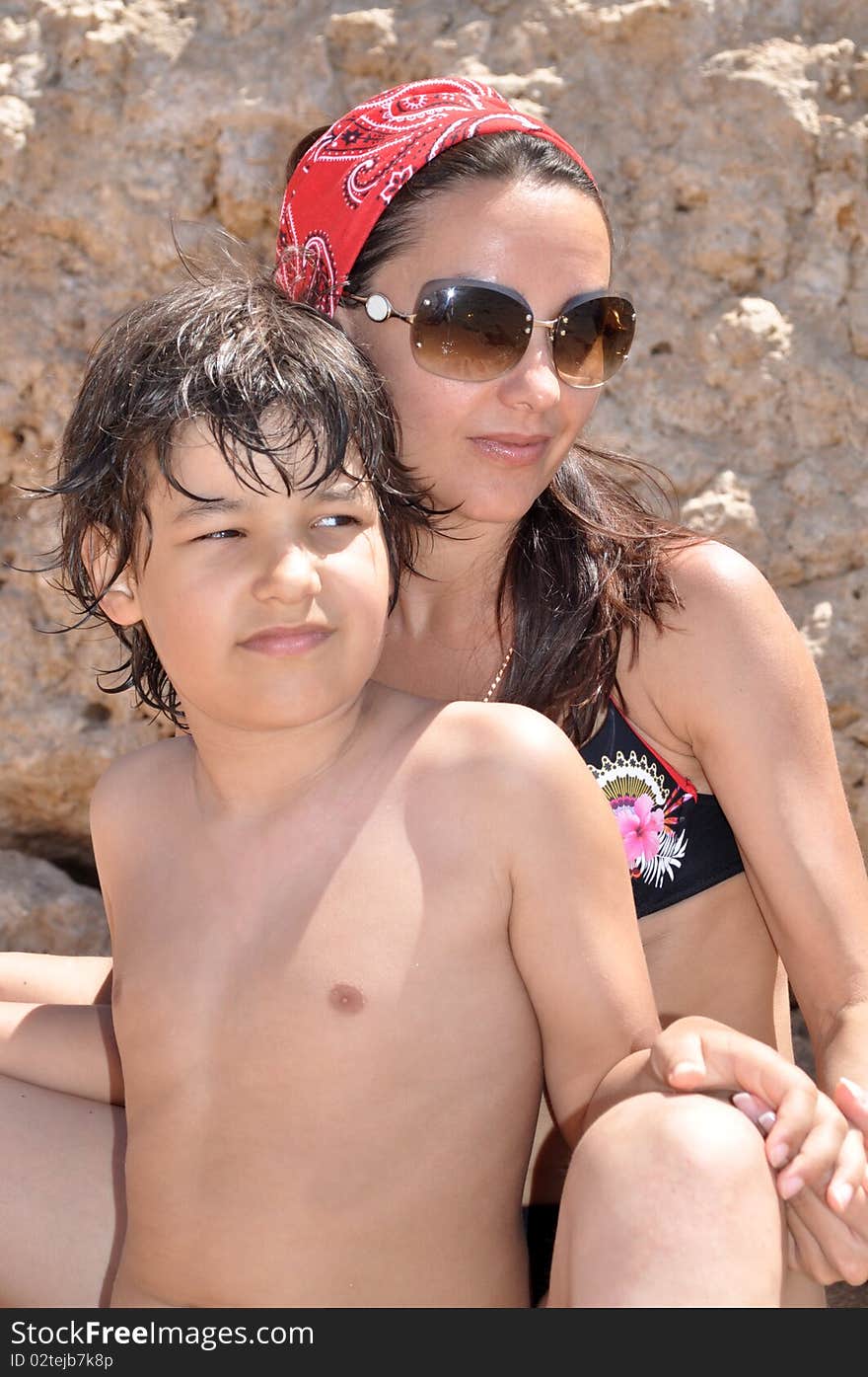 A boy and a young woman on the beach under the bright sun. A boy and a young woman on the beach under the bright sun