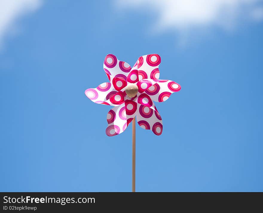 A plastic windmill toy against a blue sky