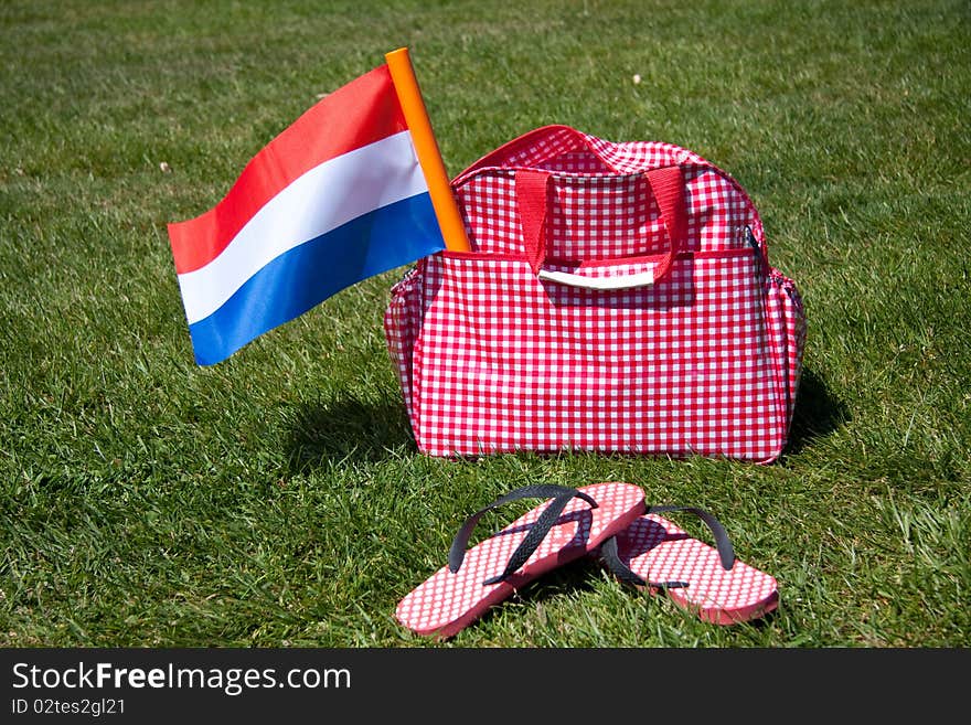 The Dutch Flag in a travelbag on a green lawn
