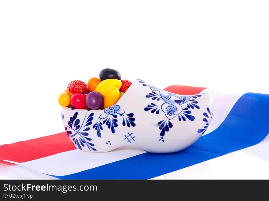 Old Dutch candy fruit in a Delft blue clog on a Dutch Flag isolated over white