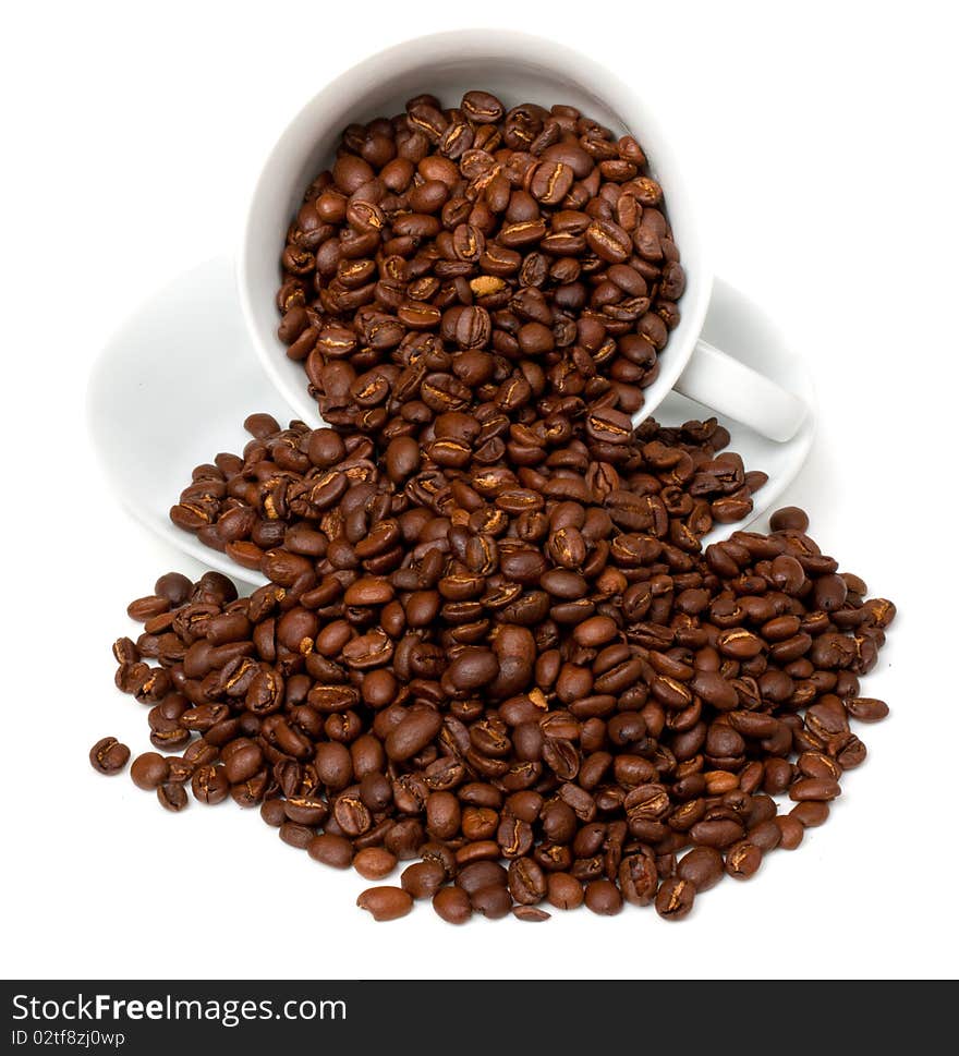 Coffe Beans  spilling out of white cup and saucer. Coffe Beans  spilling out of white cup and saucer