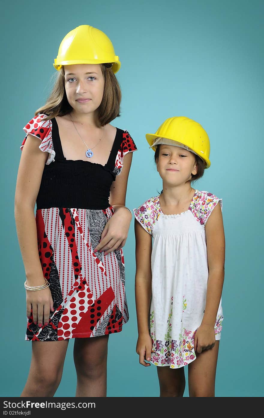 Two beautiful children showing yellow construction equipments. Two beautiful children showing yellow construction equipments