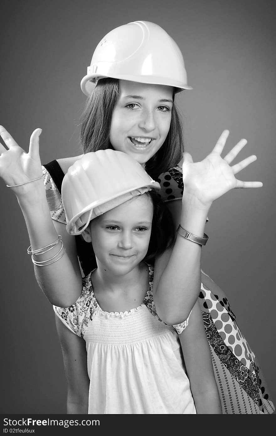 Two beautiful children showing yellow construction equipments. Two beautiful children showing yellow construction equipments