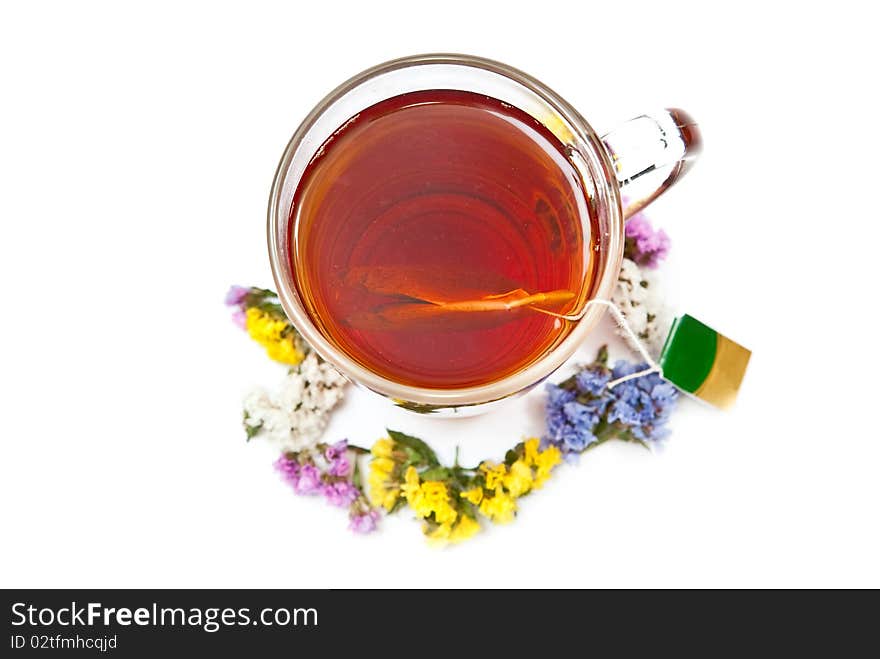 Hot tea in glass cup with flowers. Isolated on white