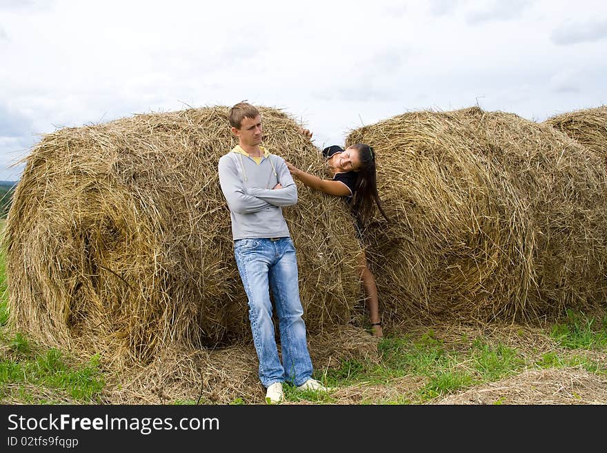 Young couple costs about a haystack