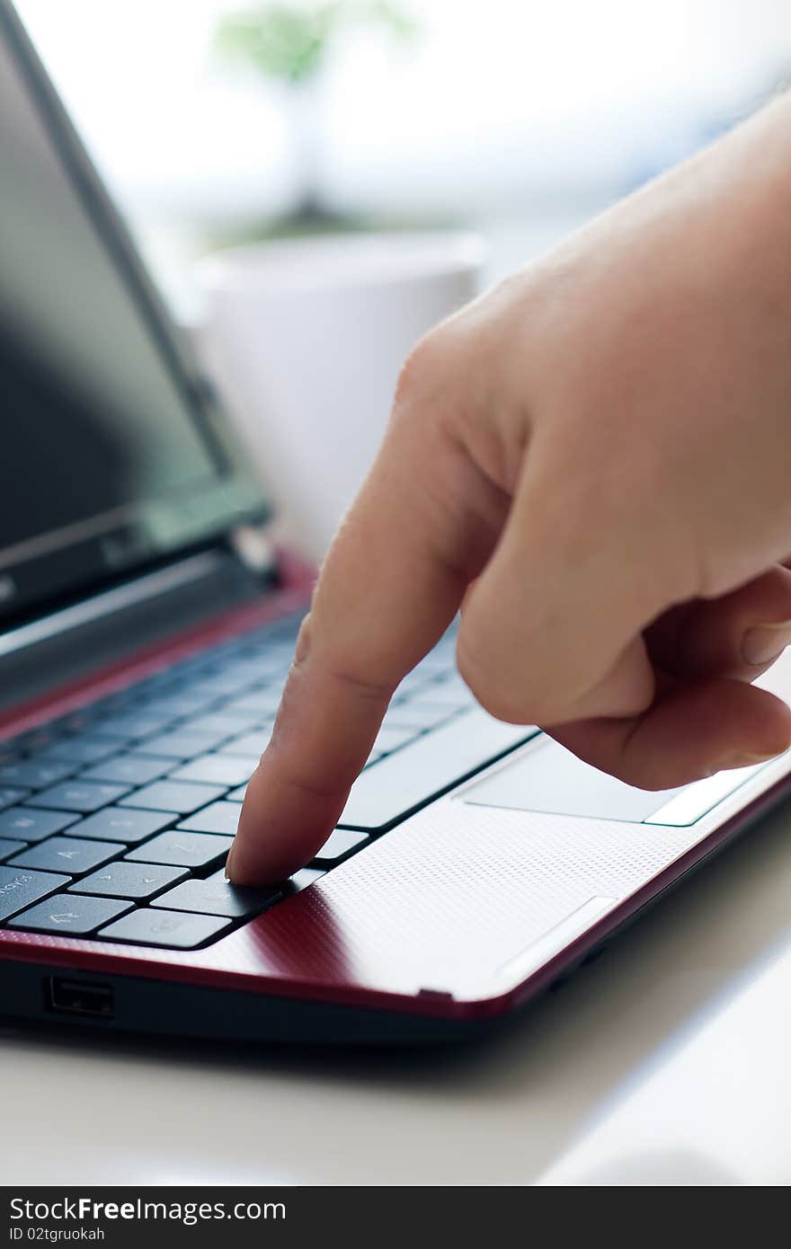 Hands typing on laptop in office